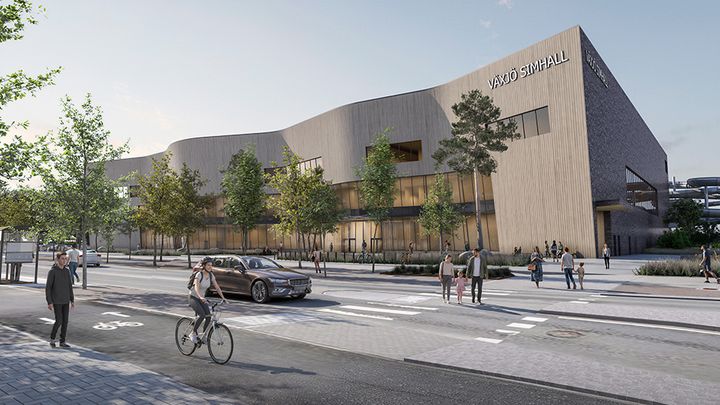 Visualisering av Växjö simhall med vågformad träfasad, människor, cykel och bil i en stadsmiljö.