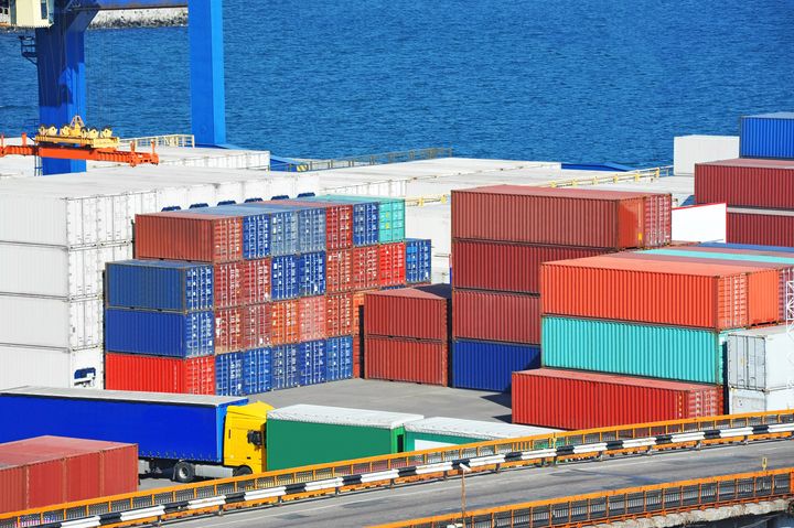 Fraktcontainrar och lastbilar på en containerterminal vid kajen.