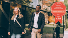 Bild på två glada personer som går framför en Vy bus4you-buss. En utmärkelse från SKI syns för Sveriges nöjdaste privatkunder inom persontransport 2025.