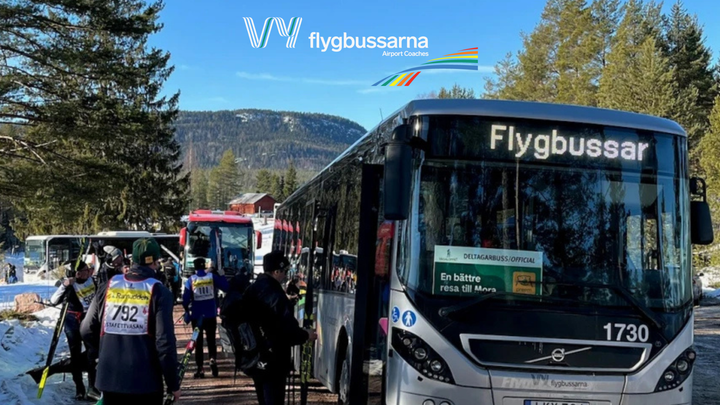 Vy flygbussarna vid en hållplats under Vasaloppet, med skidåkare i närheten.