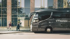 Vy bus4you vid en vägg. Två personer som går mot bussen.