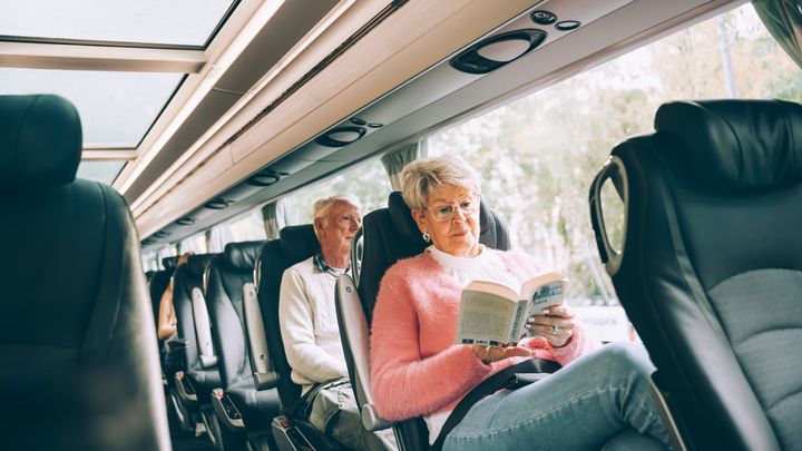 Två personer sitter bekvämt i en Vy bus4you.