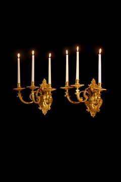 ANDRÉ-CHARLES BOULLE (cabinetmaker, sculptor and bronzier in Paris, 1642–1732). A pair of appliques, high-quality Parisian works in the Louis XIV style, circa 1715, each for three lights, in polished and matt-punched fire-gilt bronze.