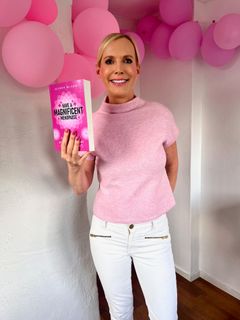 Alison Bladh står med sin bok "Have a Magnificent Menopause" på lanseringsdagen, omgiven av färgglada ballonger – en hyllning till framgången som internationell bästsäljare.