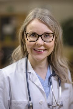 Porträtt av kvinna i vit läkarrock med stetoskop