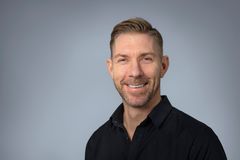 En leende man i svart skjorta.