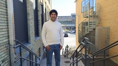 Aftab Nadeem står i trappa på campuset Umeå universitet.