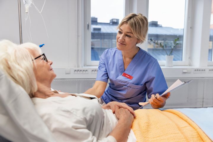 Sjuksköterska vid bädd hos patient