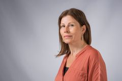 Porträtt på kvinna framför grå vägg