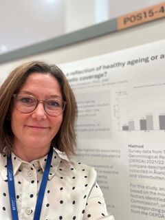 En kvinna med glasögon står framför en affisch som visar forskningsdata.