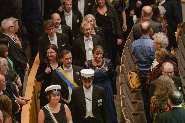 Universitetsledningen i högtidsdräkt tågar in mellan sittande gäster under Årshögtiden 2025.