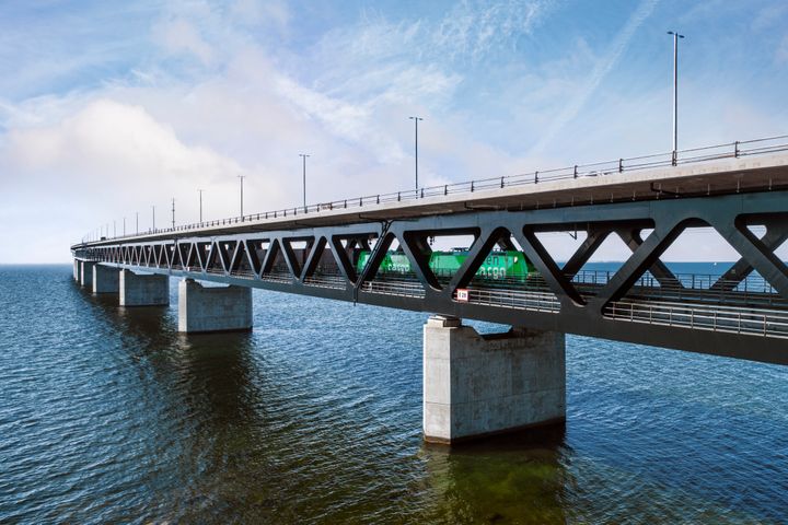 Green Cargos godståg kör över Öresundsbron en vacker sommardag.