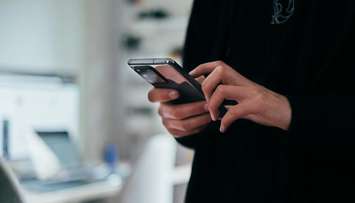 En person håller i en smartphone och använder den.