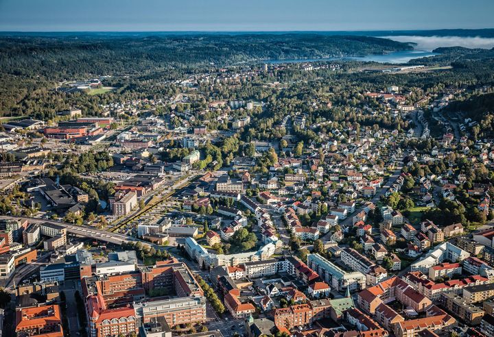 Flygfoto över en Borås med många byggnader och omgivande skog.