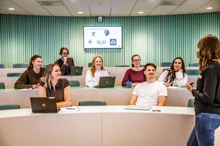 En grupp studenter i ett klassrum lyssnar på en föreläsare.
