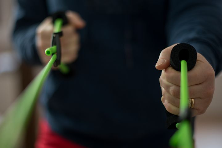 Person som använder gröna motståndsband för träning.