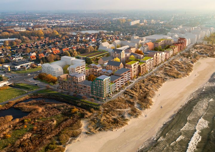 Flygfoto av Västra Sjöstaden i Trelleborg med bostadshus, sanddyner och havet i förgrunden.