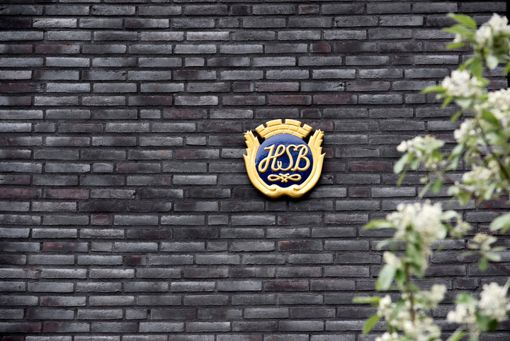 Svart tegelvägg med HSB-sköld