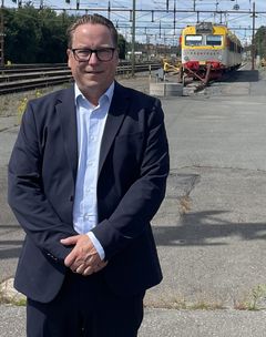 Anders Ekman, ny vd för Krösatågen, står vid en perrong på Nässjö station med ett krösatåg i bakgrunden.