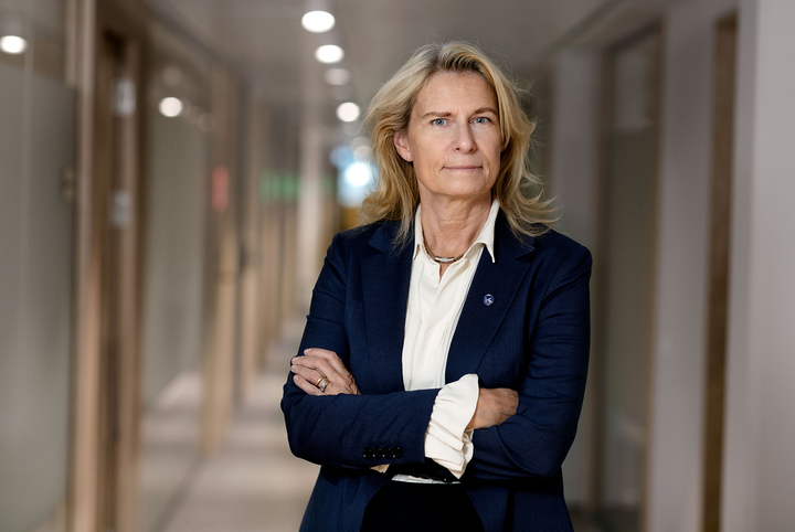 Katarina Bjelke i halvfigur ståendes i en korridor med armarna i kors.