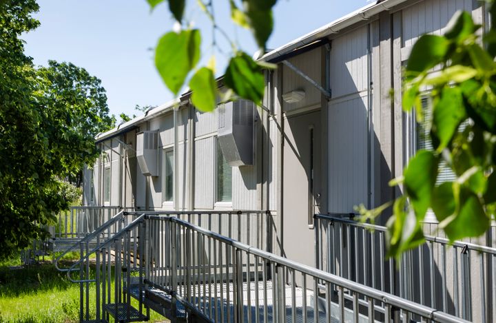 Harmaa%20moduulirakennus%2C%20johon%20johtaa%20esteet%F6n%20luiska.%20Ymp%E4rill%E4%20kasvillisuutta.