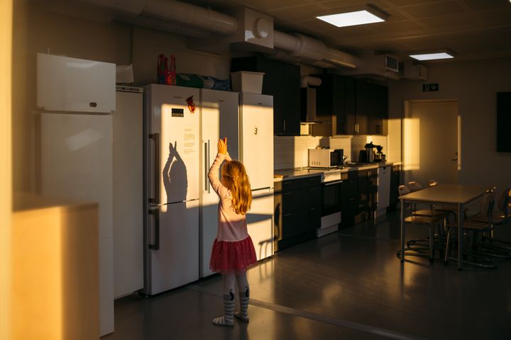 Lapsi%20seisoo%20keitti%F6tilassa%20ja%20kurkottaa%20j%E4%E4kaapin%20ovea%2C%20auringonvalo%20lankeaa%20sis%E4%E4n%20l%E4mpim%E4sti.