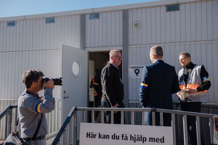 Ihmisi%E4%20moduulirakennuksen%20sis%E4%E4nk%E4ynnin%20edustalla%20valmiusharjoituksen%20tai%20tapahtuman%20yhteydess%E4.%20Kuvassa%20n%E4kyy%20my%F6s%20valokuvaaja%2C%20avattu%20ovi%20sek%E4%20opasteita%20rakennuksen%20ulkopuolella.