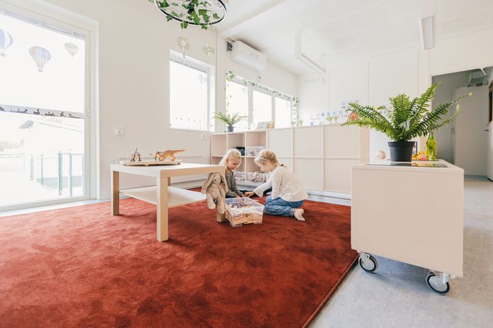 Kaksi%20lasta%20leikkii%20lattialla%20valoisassa%20p%E4iv%E4kotitilassa.%20Avoin%20ja%20kodikas%20oppimisymp%E4rist%F6%20tarjoaa%20tilaa%20leikille%2C%20yhdess%E4ololle%20ja%20varhaiskasvatuksen%20arjelle.
