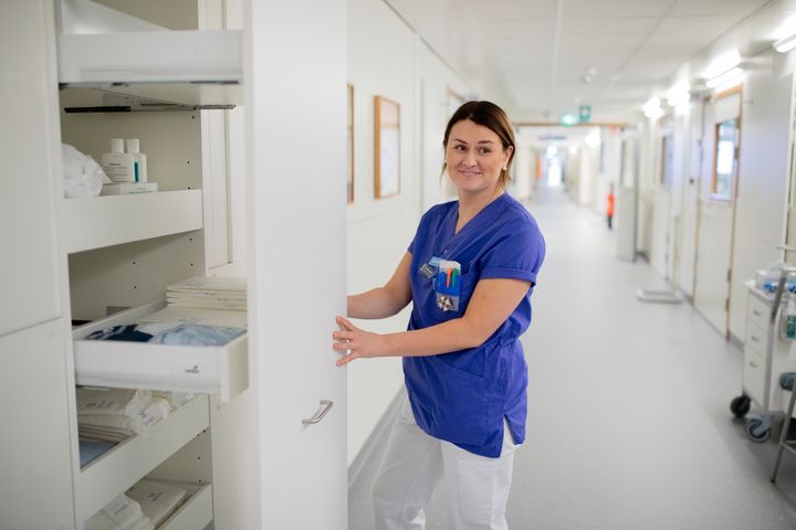 Hoitaja%20ottaa%20tarvikkeita%20s%E4ilytyskaapista%20valoisassa%20hoivayksik%F6n%20k%E4yt%E4v%E4ss%E4.%20Hyvin%20suunnitellut%20ja%20toimivat%20tilat%20tukevat%20hoitohenkil%F6kunnan%20p%E4ivitt%E4ist%E4%20ty%F6t%E4%20sek%E4%20sujuvaa%20hoivaty%F6t%E4.