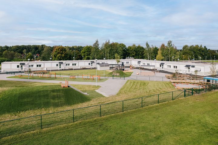 Moduuleista%20rakennettu%20p%E4iv%E4koti%2C%20jonka%20pihalla%20on%20leikki-%20ja%20ulkoilualueita.