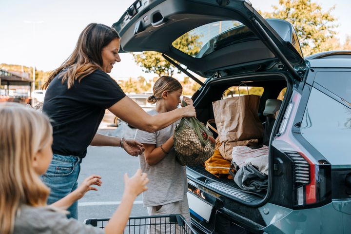 Familj lastar in varor i bilen