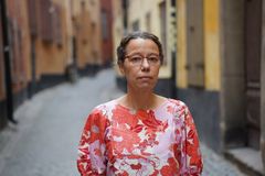 Meriam Chatty står på en stenlagd gata omgiven av byggnader.