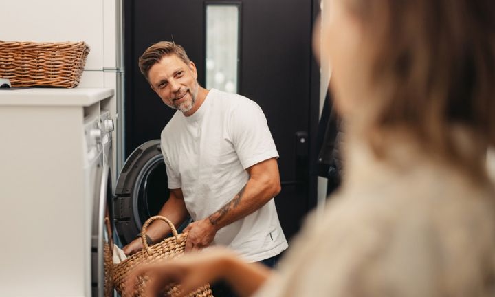 En man och en kvinna i en tvättstuga. Mannen i bakgrunden