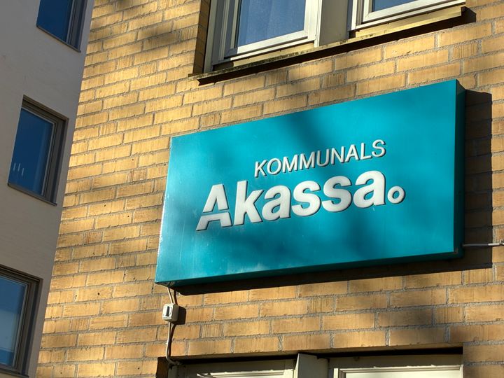 Skylt med texten "Kommunals A-kassa" på en tegelvägg.