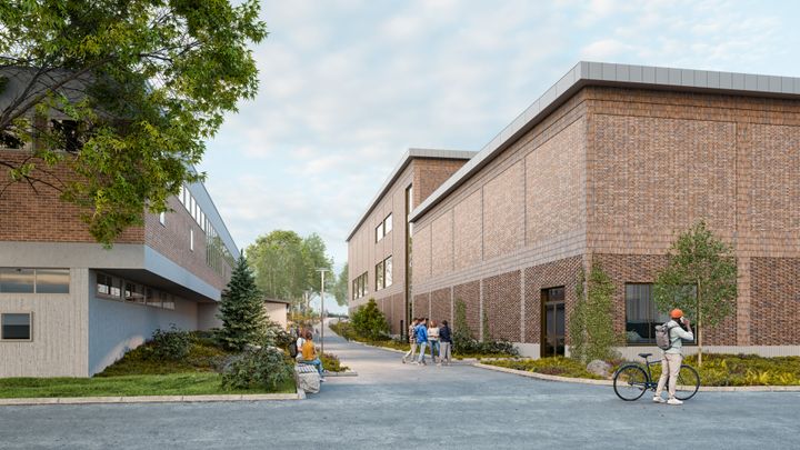 Alt%20text%3A%20Tv%E5%20tegelbyggnader%20med%20moderna%20inslag%20och%20m%E4nniskor%20som%20r%F6r%20sig%20utanf%F6r.