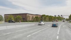 En modern byggnad vid en bred väg, omgiven av träd.