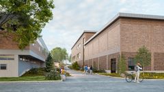 Alt text: Två tegelbyggnader med moderna inslag och människor som rör sig utanför.