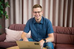 Bild på en leende man vid en dator.