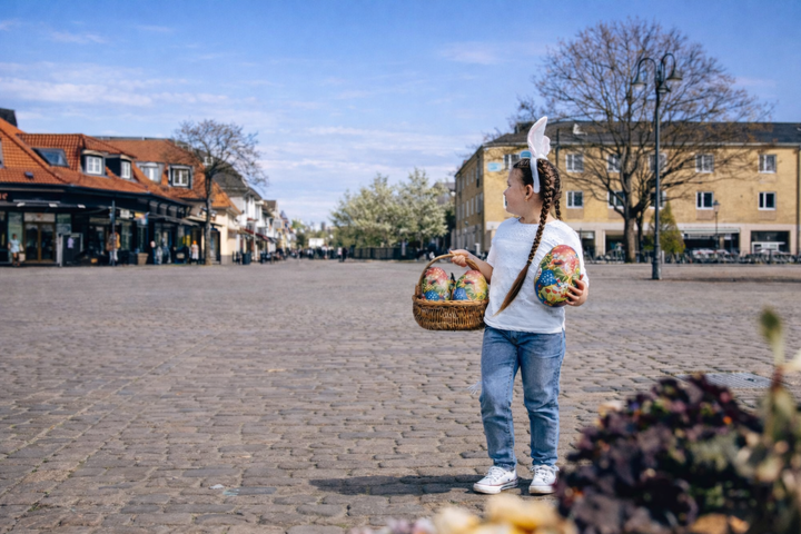 Flicka på Varbergs torg med en korg fylld av påskägg.