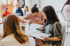 Elever som sitter i en bildsal och målar