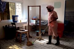 Barnmorskan Shenette Khaula Shamu städar förlossningsrummet efter en förlossning på Diah Clinic i Grand Cape Mount, Liberia.