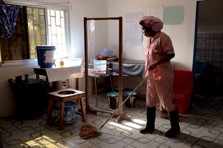 Barnmorskan Shenette Khaula Shamu städar förlossningsrummet efter en förlossning på Diah Clinic i Grand Cape Mount, Liberia.