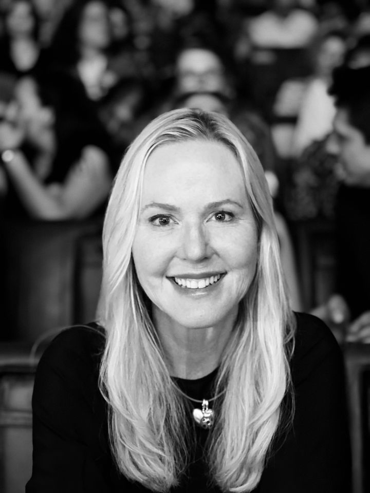 Kvinna med långt ljust hår ler mot kameran.