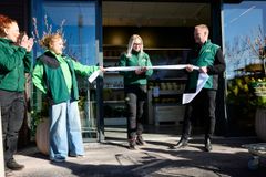 Alt-text: Butikschef Mikaela Frelin klipper invigningsbandet framför Blomsterlandets nya butik i Mora. Hon är omgiven av VD Susanne Holmström och försäljnings- och marknadschef Håkan Wulff.
