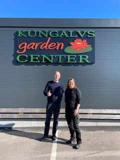 Två personer står framför skylten till Kungälv Garden Center.