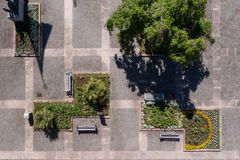 Flygfoto av en geometriskt utformad trädgård med olika planteringar och träd.