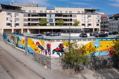 Muralmålning på en byggnad med färgglada djurmotiv och abstrakta former.