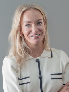 Kvinna i vit skjorta tittar in i kameran