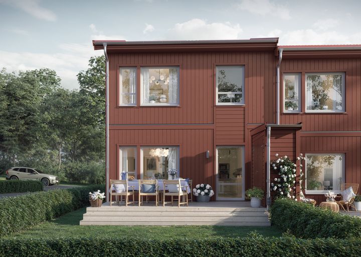 Rött radhus med uteplats och trädgård.