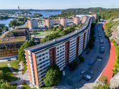 Lång fastighet i rött tegel längs med väg.
